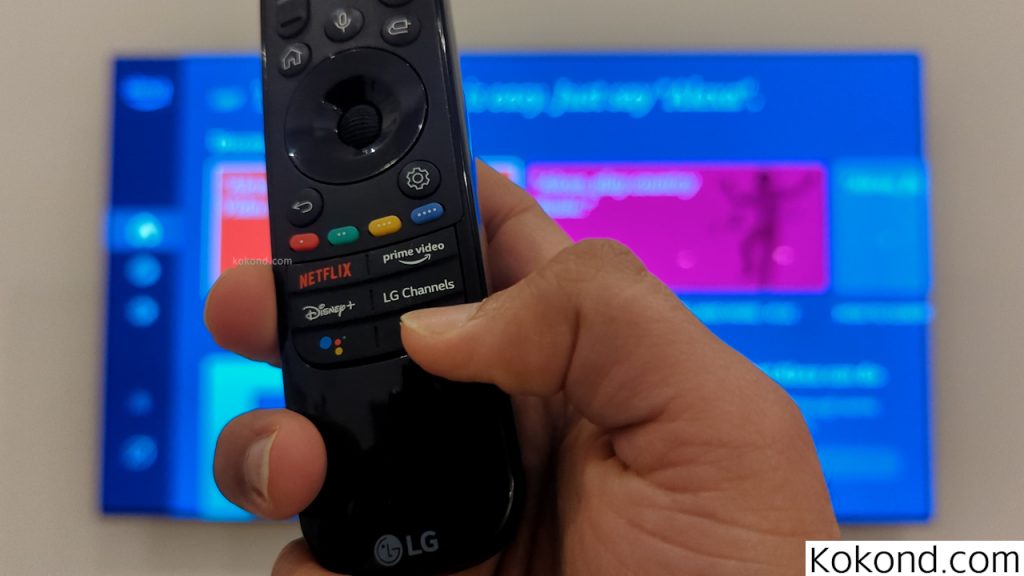 The image user holding the TV remote and pressing down the Alexa button. 